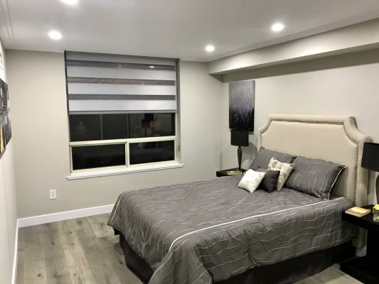 Image depicts a bedroom with newly painted light grey walls.