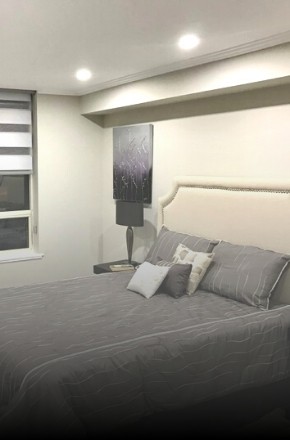 Image depicts a bedroom with walls and baseboard painted by Arkadys Painting.